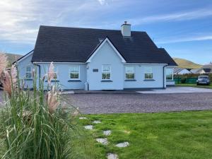 a white house with a black roof at Seagull Cottage B&B in Portmagee