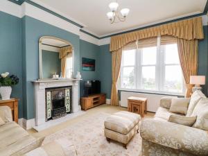 a living room with a couch and a fireplace at Heanor House in Leyburn