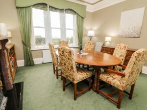 uma sala de jantar com uma mesa de madeira e cadeiras em Heanor House em Leyburn