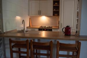 a kitchen with a counter with chairs and a sink at House Antica in Lastovo