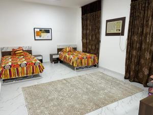 a bedroom with two beds and a rug at Al Shiya Chalet in Sur