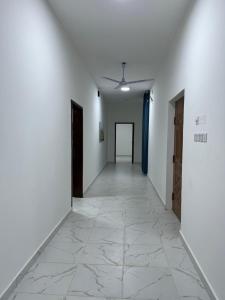a hallway with white walls and a tile floor at Al Shiya Chalet in Sur +3 photos