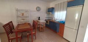 a kitchen with a table and a white refrigerator at Apartamento El Cercado Mogan in Mogán