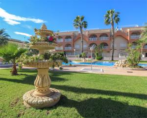 una estatua en el césped frente a un edificio en Lovely 2 bed, 2 bath apt with 2 large pools, en Los Alcázares