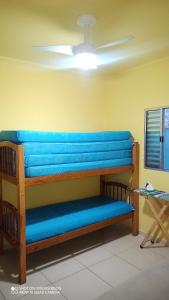 Un banco azul en una habitación con techo en Casa com piscina , churrasqueira, Wi-Fi, em rua de Areia à 1km da praia, bairro sussegado, proíbido uso de som extremamente alto ideal para descansar, en Itanhaém