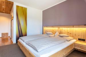 a bedroom with a large bed with a wooden headboard at Hohenegg Apartment Julian in Sarntal
