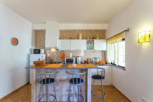 a kitchen with a counter and some stools in it at As Casas do Algarve in Vale da Rosa