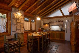 cocina con mesa de madera y nevera en Cabañas Cumelen en Villa Gesell