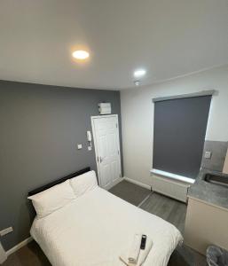 盧頓的住宿－Luton Short Term Lets - Cardiff Road，卧室配有白色的床和窗户。