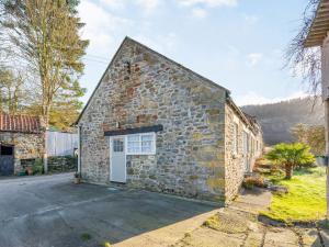 a stone building with a door on the side of it at Feather Holme Farm Cottage in Hawnby