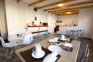 a room with a table and chairs and a kitchen at La Rukka Hostal Boutique in San Pedro de Atacama