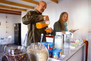 un homme et une femme debout dans une cuisine préparant la nourriture dans l'établissement La Rukka Hostal Boutique, à San Pedro de Atacama