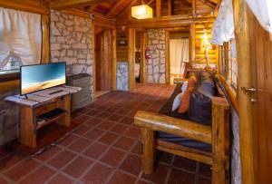 Cabaña con sala de estar con sofá y TV. en Cabañas Cumelen en Villa Gesell