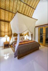 a bedroom with a large bed with a canopy at Bintang Bungalow in Nusa Penida