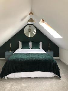 a bedroom with a green and white bed in a attic at Little Oaks in Pembrokeshire