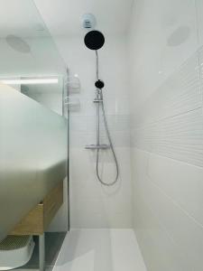 biała łazienka z prysznicem i umywalką w obiekcie Spacious modern house near the Golf of Ardrée w mieście Saint-Antoine-du-Rocher