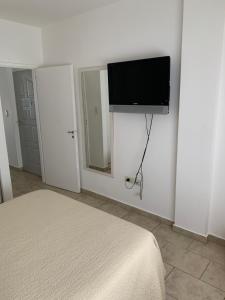 a bedroom with a bed and a flat screen tv on the wall at Fenix 1 in Colón