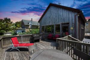 una terraza con una silla roja y una mesa en Quaint Riverfront Barn, en Kankakee