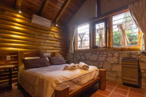 1 dormitorio con 1 cama con 2 zapatillas en Cabañas Cumelen en Villa Gesell