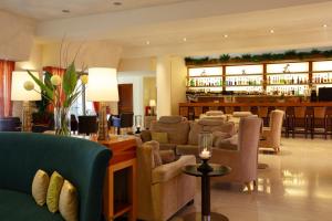a lobby with couches and a bar in the background at Giannoulis - Santa Marina Plaza (Adults Only) in Agia Marina Nea Kydonias