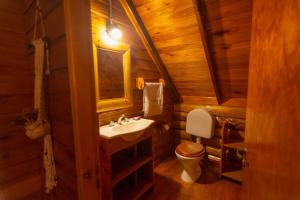 a bathroom with a sink and a toilet in a log cabin at Cabañas Cumelen in Villa Gesell +38 photos