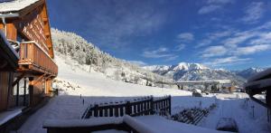 uma vista para uma montanha coberta de neve a partir de uma casa em Chalet Hôtel Les Blancs em Pra-Loup