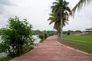 a walkway along the water with palm trees at Lake View Hotel and Resort in Jodhpur