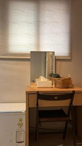 un escritorio con espejo y una cesta. en Chris Hostel, en Seúl