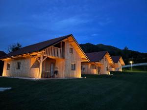 a large wooden barn with a large grass field at Family Bungalow Glamping Laško in Laško