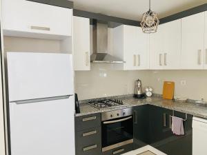 een keuken met witte kasten en een koelkast bij Aether Flats No3,Old Town,Beach,Central,Netflix in Antalya +20 foto's