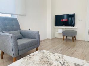 een woonkamer met een stoel en een tv bij Aether Flats No3,Old Town,Beach,Central,Netflix in Antalya