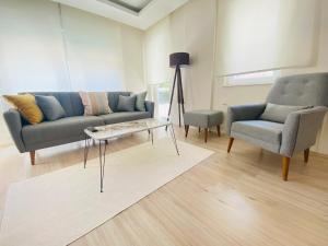 een woonkamer met een bank, twee stoelen en een tafel bij Aether Flats No3,Old Town,Beach,Central,Netflix in Antalya