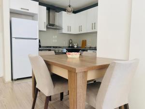 een keuken met een houten tafel en witte kasten bij Aether Flats No3,Old Town,Beach,Central,Netflix in Antalya
