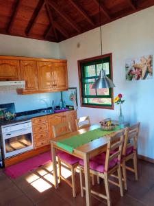 een keuken met een houten tafel en stoelen en een fornuis bij Casa Flor azul in Las Tricias