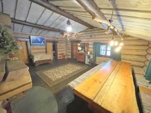 una grande stanza con un tavolo di legno in una baita di Forest hut Stariy Prud a Filippovichi