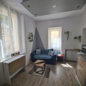 een woonkamer met een blauwe bank en een tafel bij Très joli appartement 2 pièces, centre-ville in Tuchan