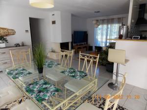 sala de estar con mesa de cristal y sillas en Maison de 3 chambres avec jacuzzi jardin amenage et wifi a Angoume, en Angoumé