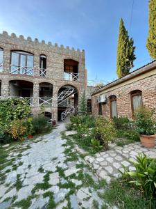 um edifício de tijolos com uma passagem em frente em Guest House Lali em Signagi