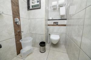 a white bathroom with a toilet and a shower at KK Comforts in Shrīrangapattana