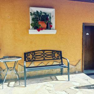 a bench next to a building with a window and a table at Tarnava - Oldtown House in Veliko Tŭrnovo