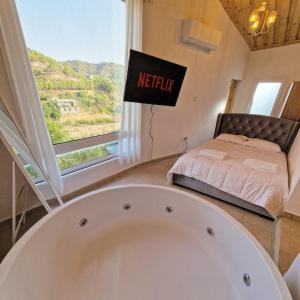 a bath tub in a room with a bed at Aprosmeno Jacuzzi House 4 in Agros