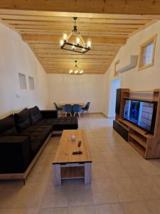 a living room with a couch and a table at Aprosmeno Jacuzzi House 4 in Agros