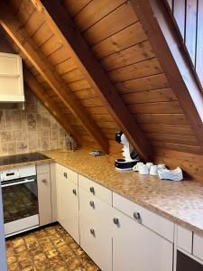 cocina con armarios blancos y techo de madera en Get Cozy Flat Zürich en Zúrich