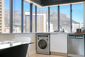 y cocina con lavadora y vistas a la montaña. en Stay In Luxury at Stonehill Place, en Ciudad del Cabo