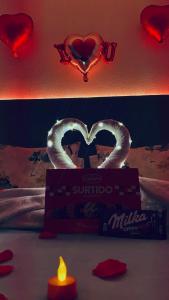 a bed with a box of subcontrolled heart and a candle at Sea Garden Peniche in Peniche