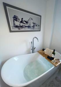 a bathroom with a bath tub with a sink at A beautiful house in a scenic town location. in Louth