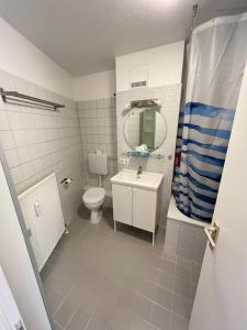 uma casa de banho com um WC, um lavatório e um espelho. em L8 Street - Monteurwohnung - Zähringerstr em Karlsruhe