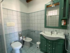 a bathroom with a sink and a toilet and a mirror at B&B Alba Chiara in Oristano