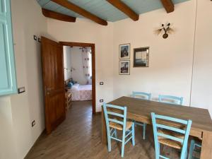 a dining room with a wooden table and chairs at B&B Alba Chiara in Oristano