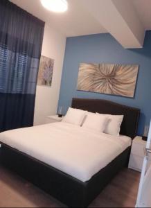 um quarto com uma grande cama branca e uma parede azul em Apartman Sara em Umag